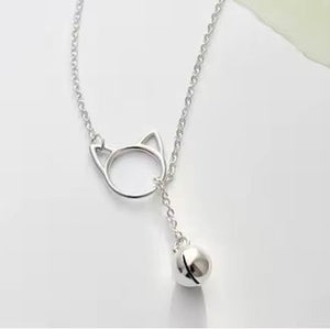 Sterling silver cat-shaped lariat necklace with a tiny silver bell on a white background