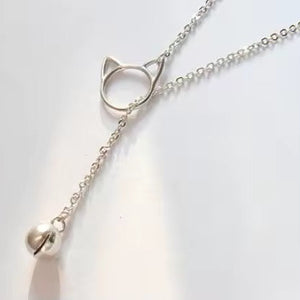 Silver necklace with a cat-shaped pendant on a light background
