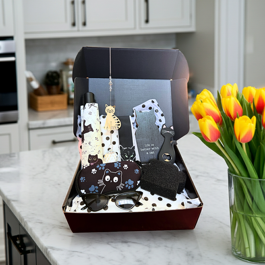 Box of cat-themed items on a kitchen counter with tulips in the background