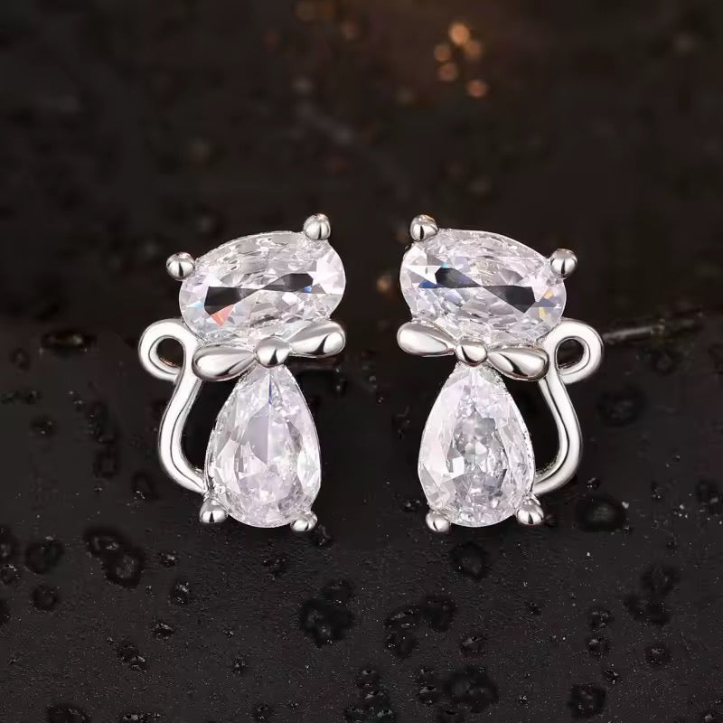 Silver Cat Earrings with Bow ties. Clear crystals create a small cat with silvertone metal accents for the ears, feet, bowtie, and tail.