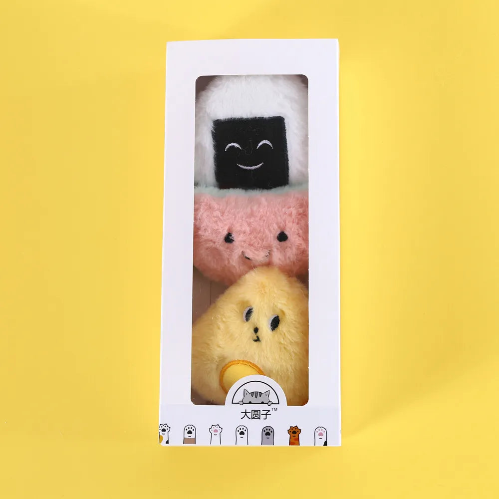 Three plush cat toys shaped like food in a box on a yellow background