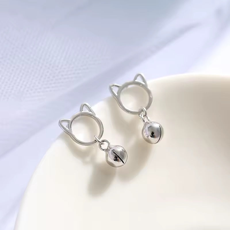 Cat-shaped earrings with a tiny bell on a white background