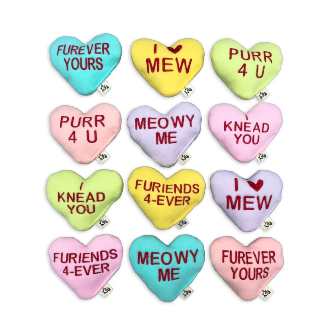 Heart-shaped cat toys with humorous text in a grid pattern on a white background