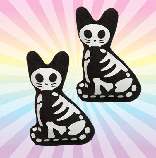 Two skeleton cat-shaped glow in the dark catnip toys on a colorful radial background