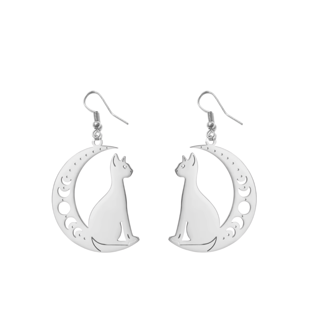 A pair of silver dangle earrings featuring a cutout cat silhouette inside a crescent moon with moon phase details, shown on a plain white background.