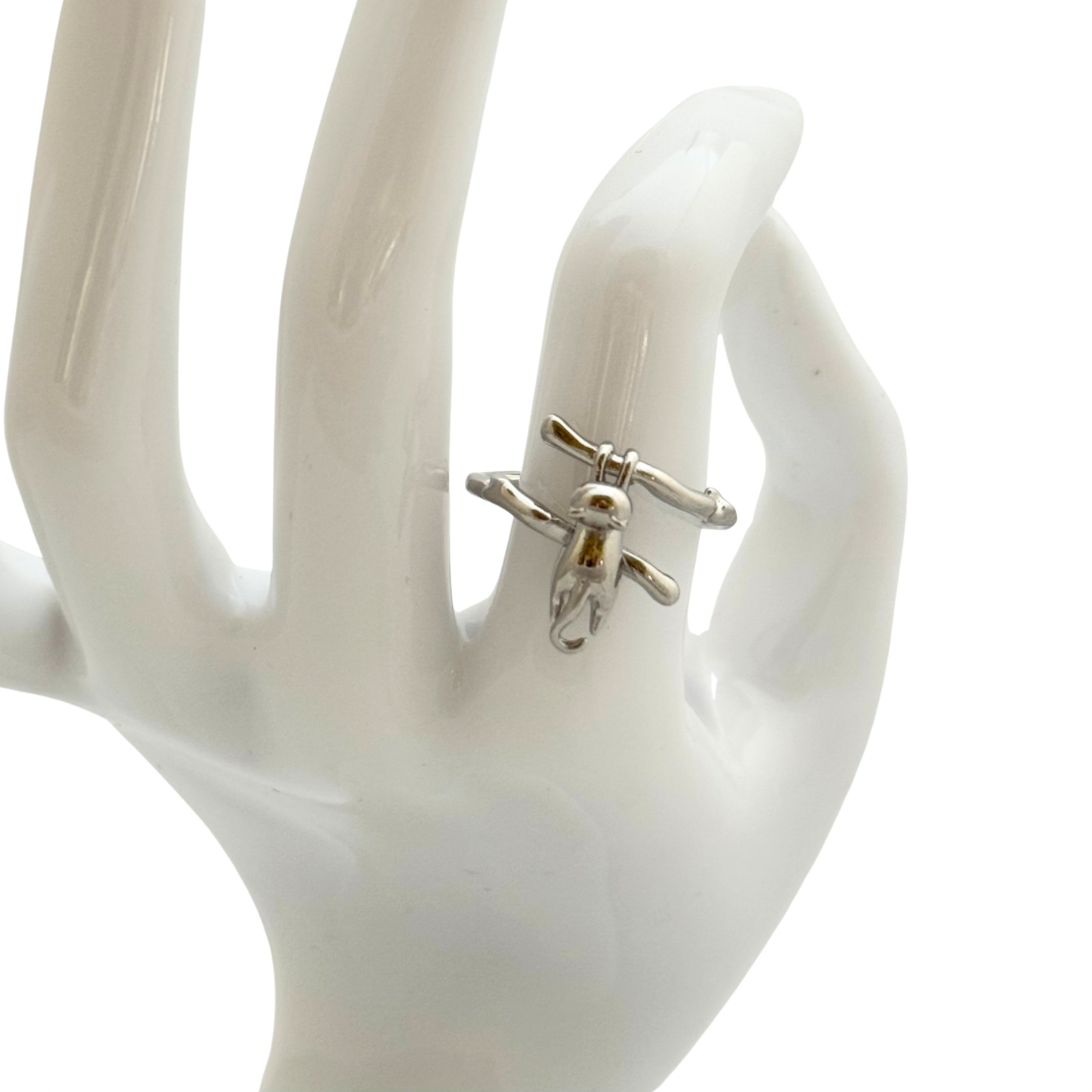 Sterling silver adjustable ring featuring a cat dangling from a branch on a white ceramic hand with white background.