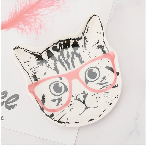 Cat-shaped ceramic trinket plate with pink glasses on a white background