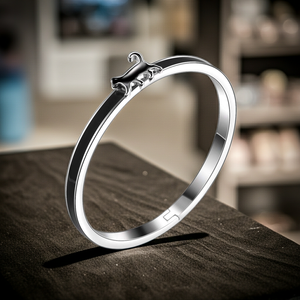 Silver Cat bangle bracelet on a wooden surface with a blurred background