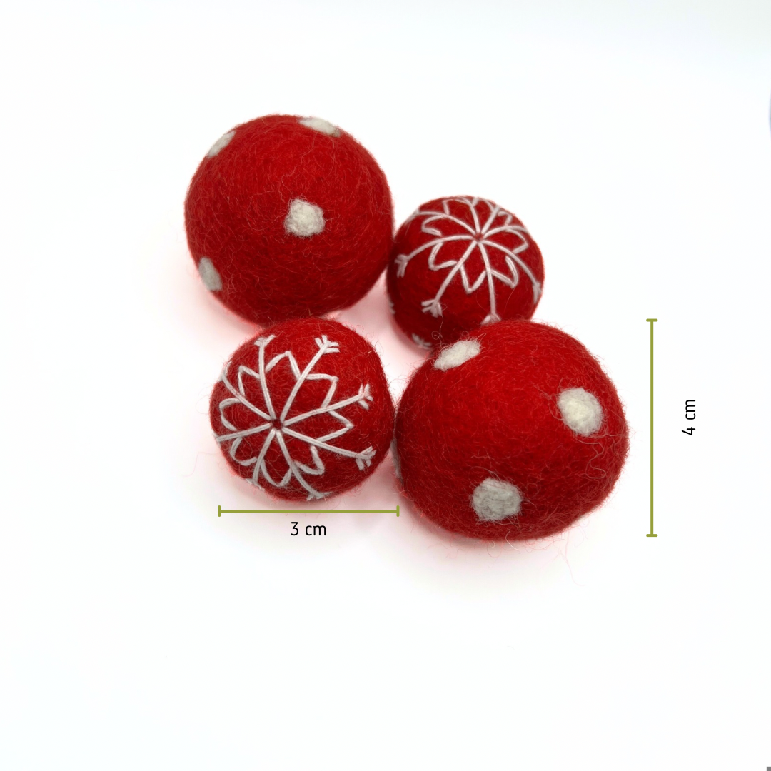 Red felt balls with white snowflake patterns and measurements on a white background