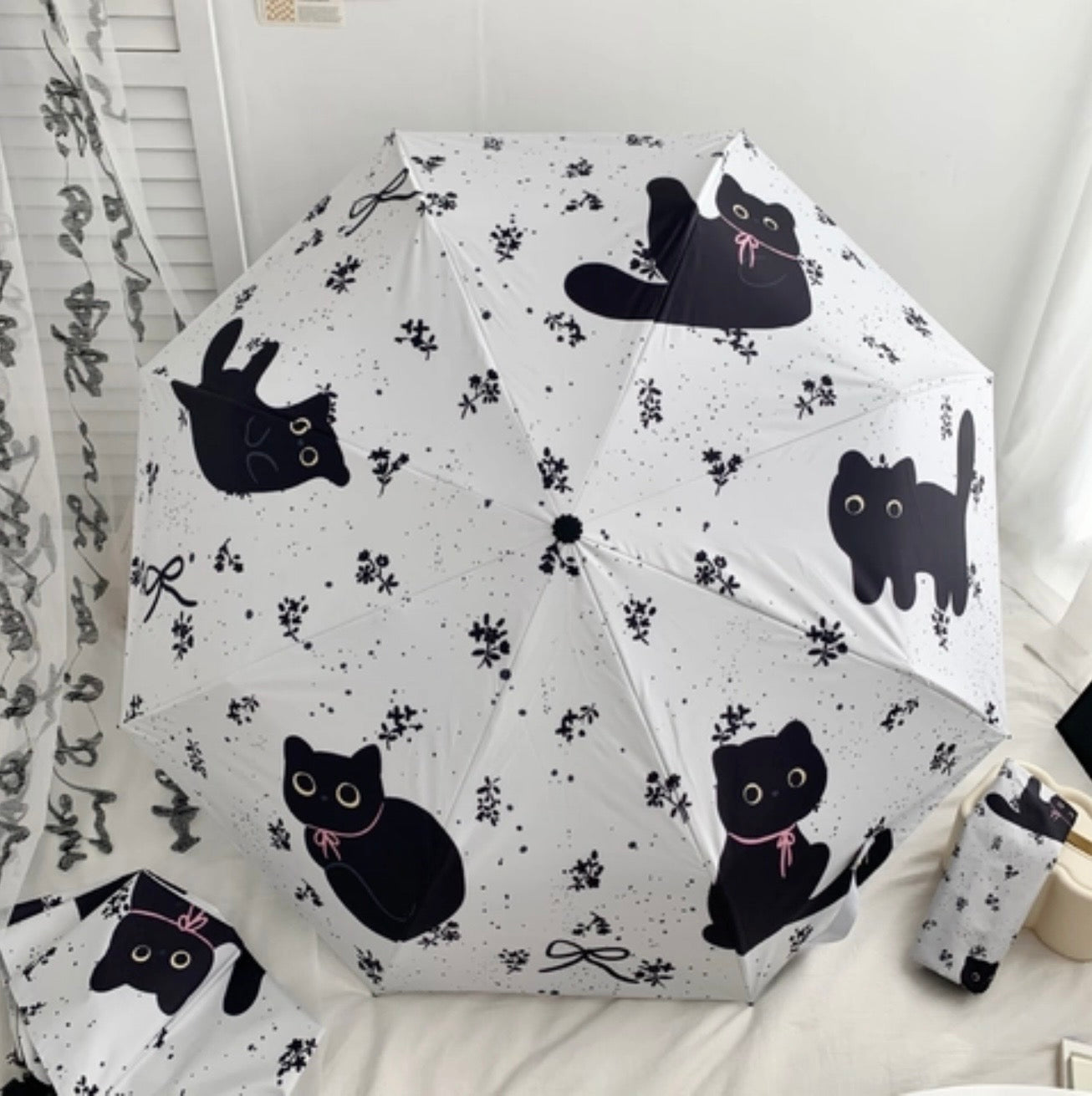 Umbrella with black cat pattern on a white background
