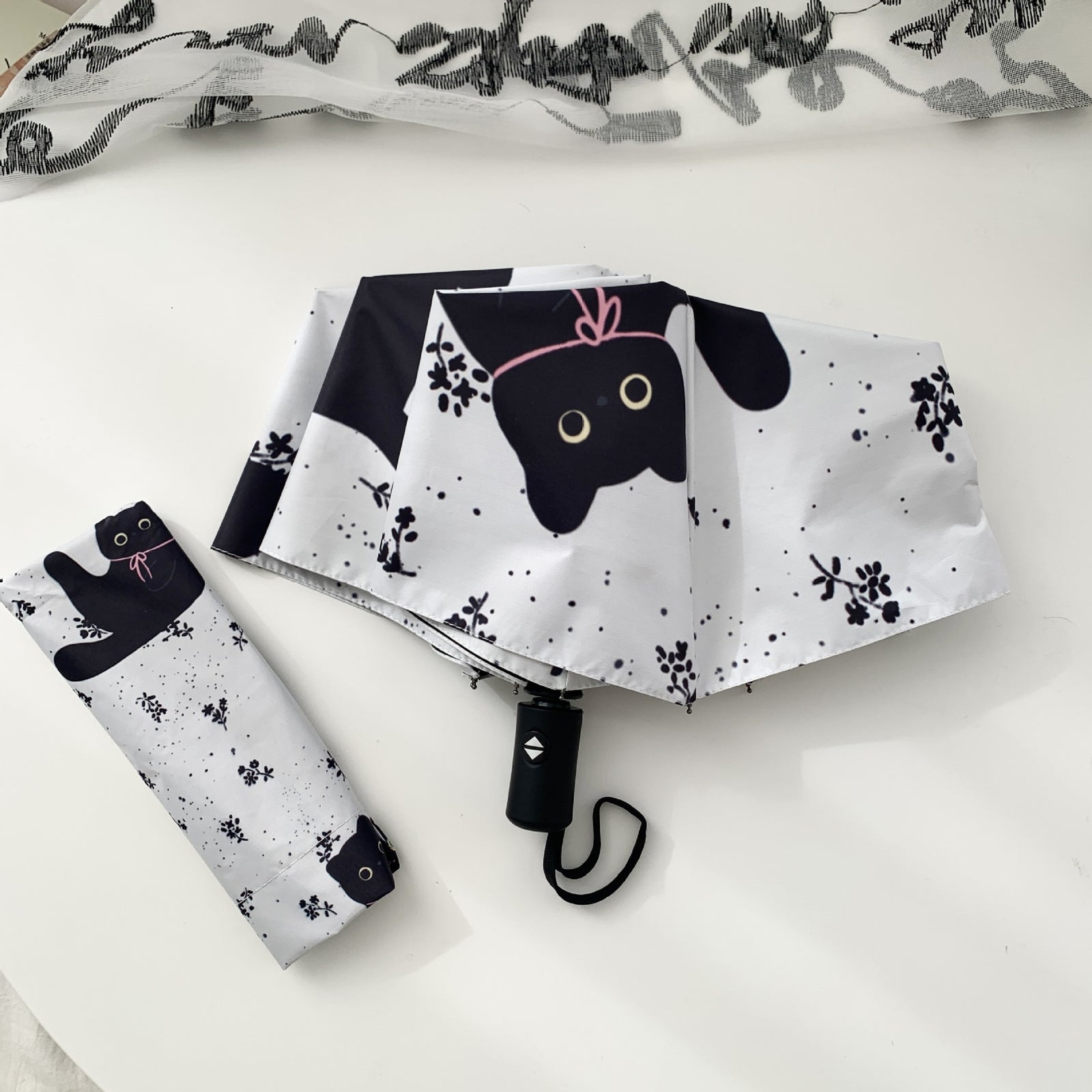Foldable UV umbrella with black cat design on a white background