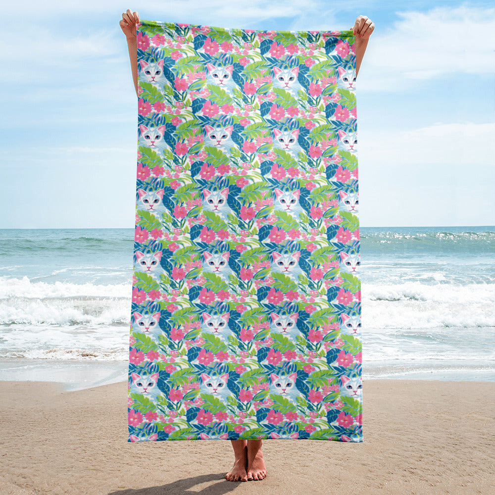Person holding a floral towel with cat pattern on a beach