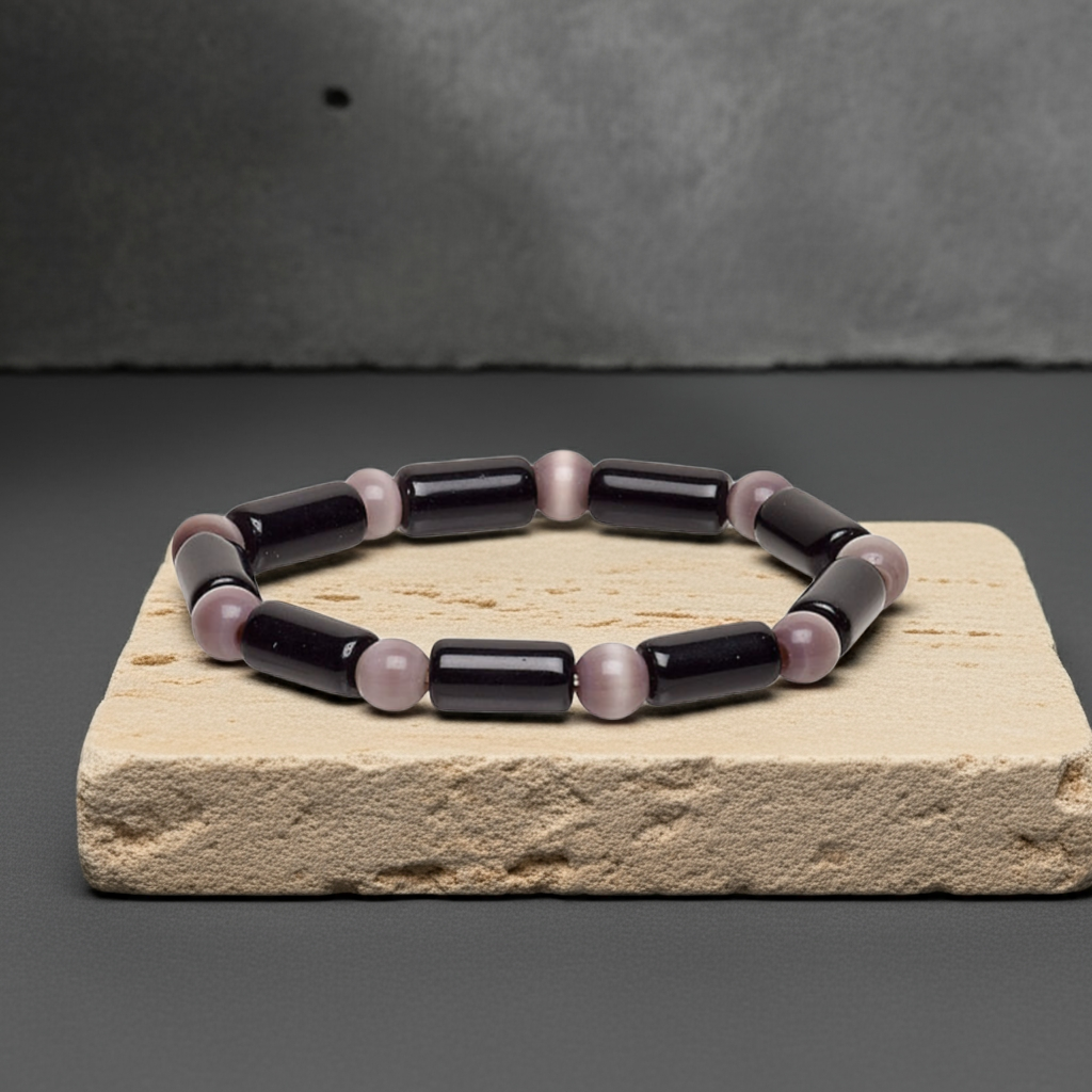 black and purple beaded bracelet sitting on concrete block