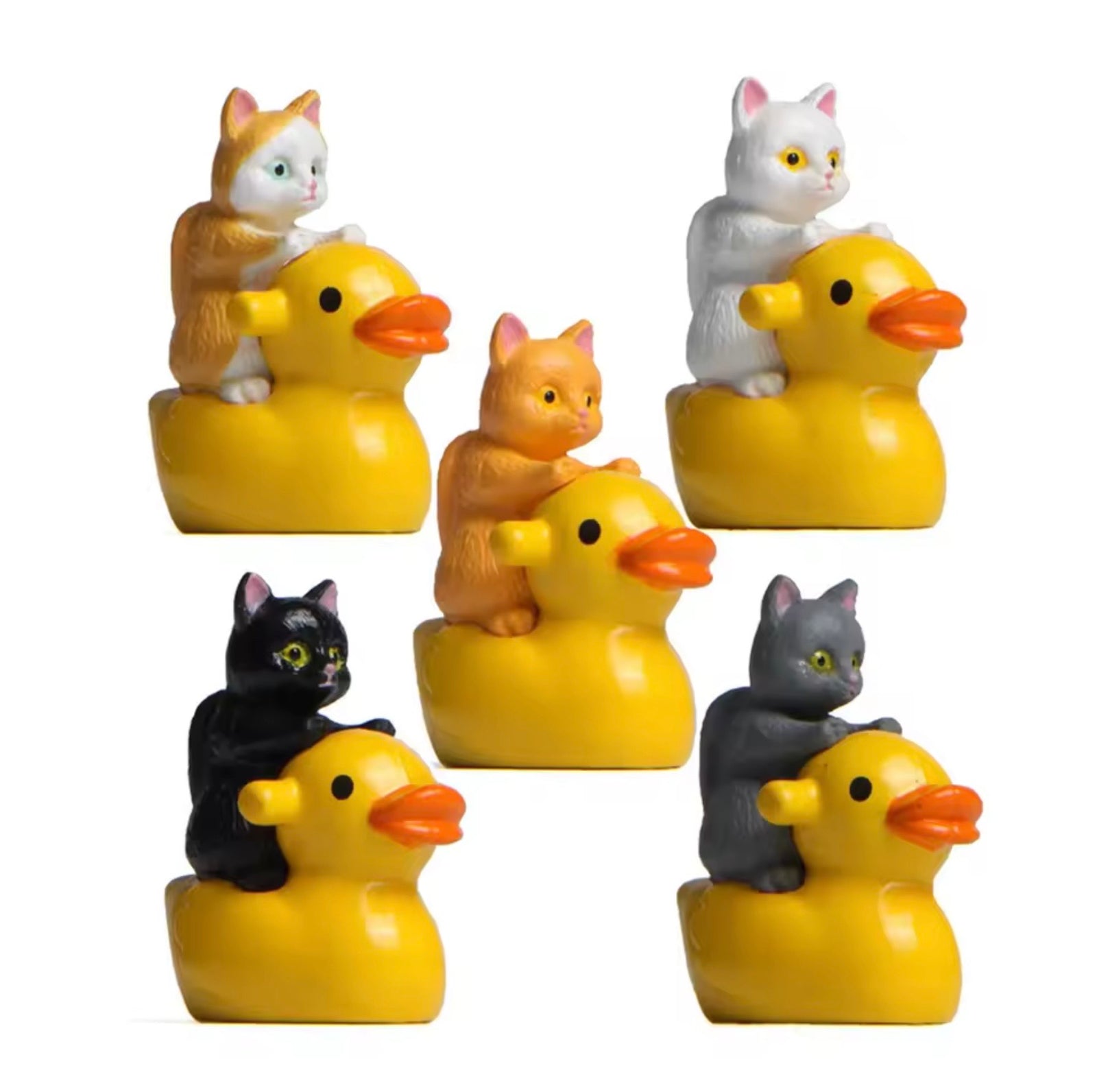 Set of rubber ducks with cats on top on a white background