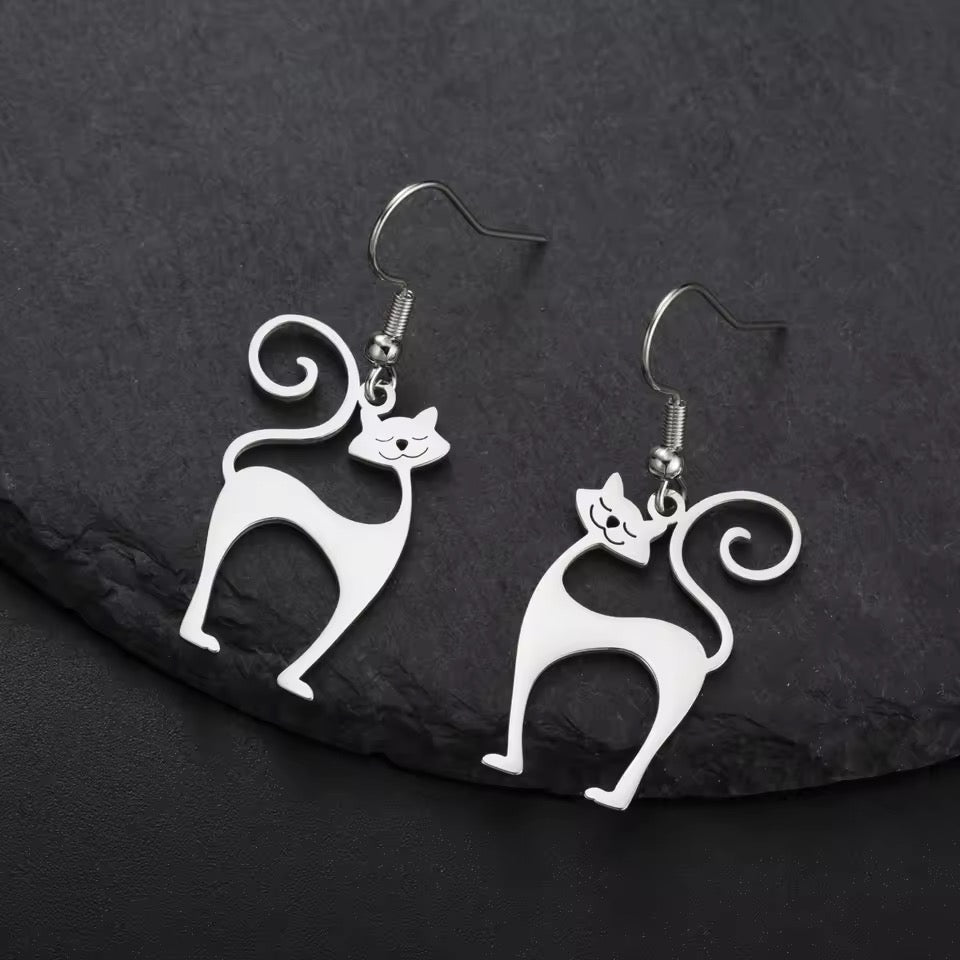 1960s space race inspired Atomic Cats as silver earrings on dark background