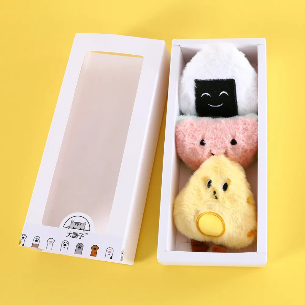 Three plush cat toys shaped like food in a box on a yellow background