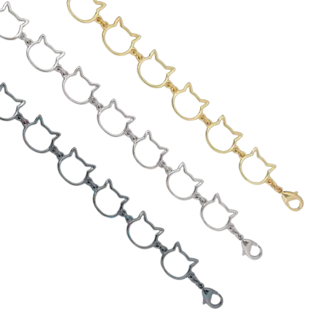 Three cat-shaped bracelets in gold, silver, and black on a white background