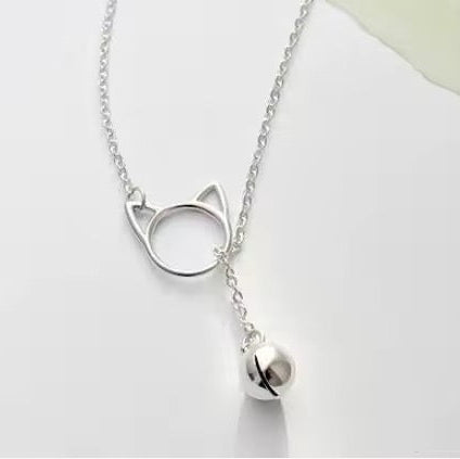 Silver plated necklace features a tiny cat bell that dangles through a Cat Head shaped loop in this adorable lariat necklace on a white background