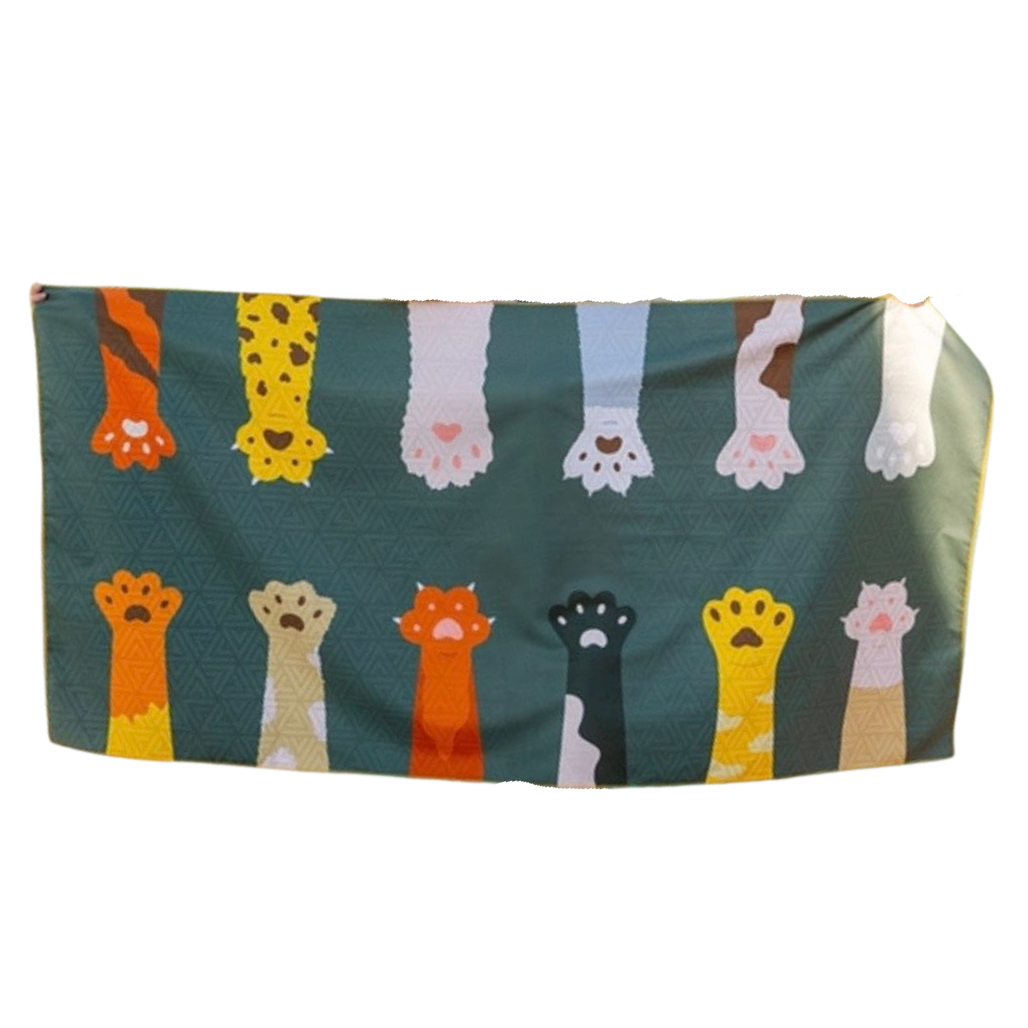Folded towel with colorful cat paw prints on a green background