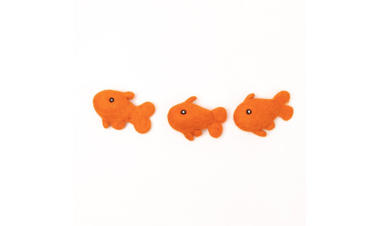 Three handmade orange wool felt goldfish with black and white eyes. Eco-friendly Cat Toys look like they’re swimming in a school.