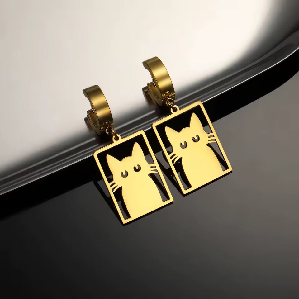 Gold hoop earrings feature a flat stainless cutout of a Cat in a Box on a silver reflective background.
