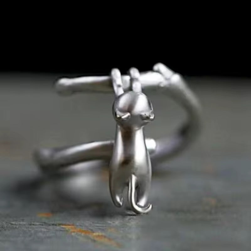 Silver cat-shaped ring on a dark background