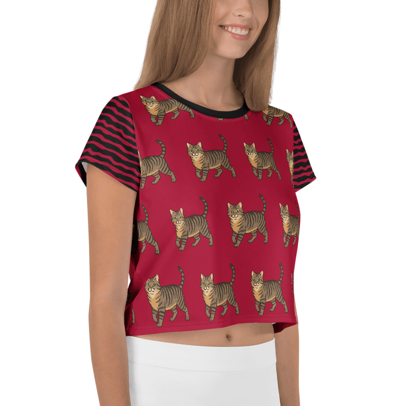 Red t-shirt with cat pattern worn by a person on a white background
