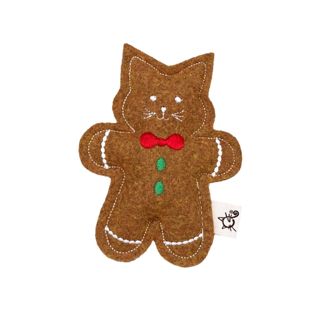 Brown gingerbread cat-shaped toy with a red bow tie on a white background