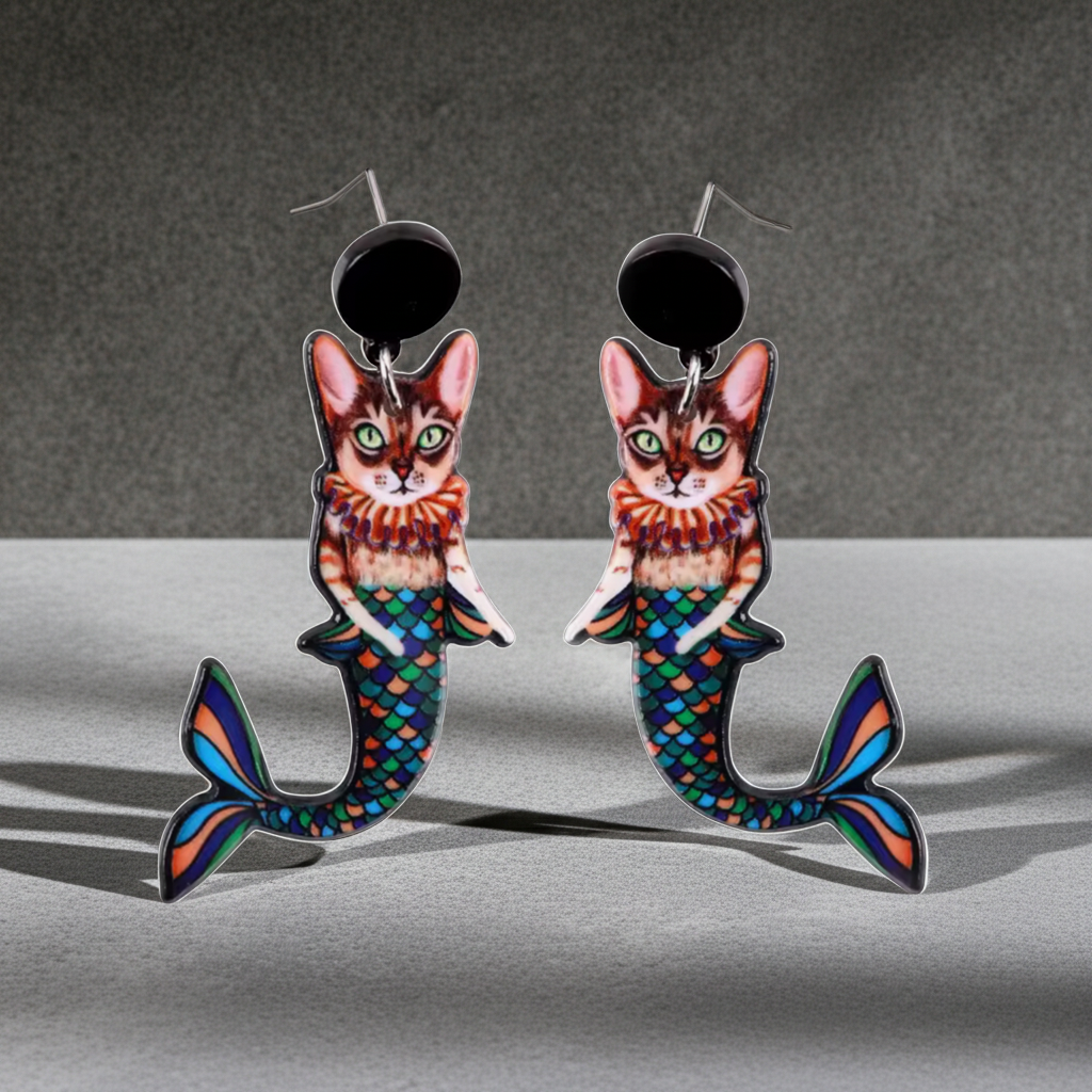 Colorful mermaid cat earrings on a gray background