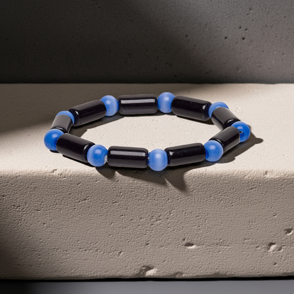 blue and black beaded bracelet sitting on concrete block