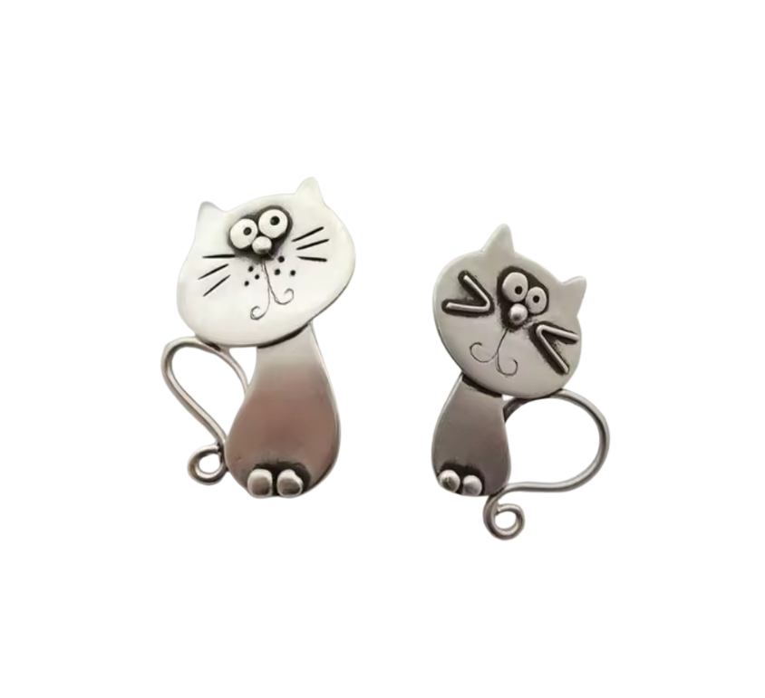 Two silver cat-shaped earrings on a white background