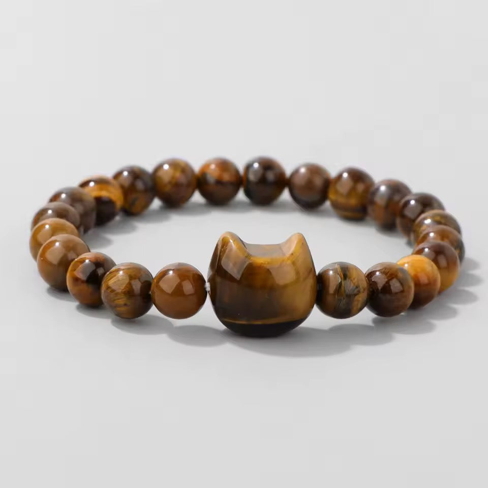 Beaded bracelet with a unique cat-shaped bead on a light gray background