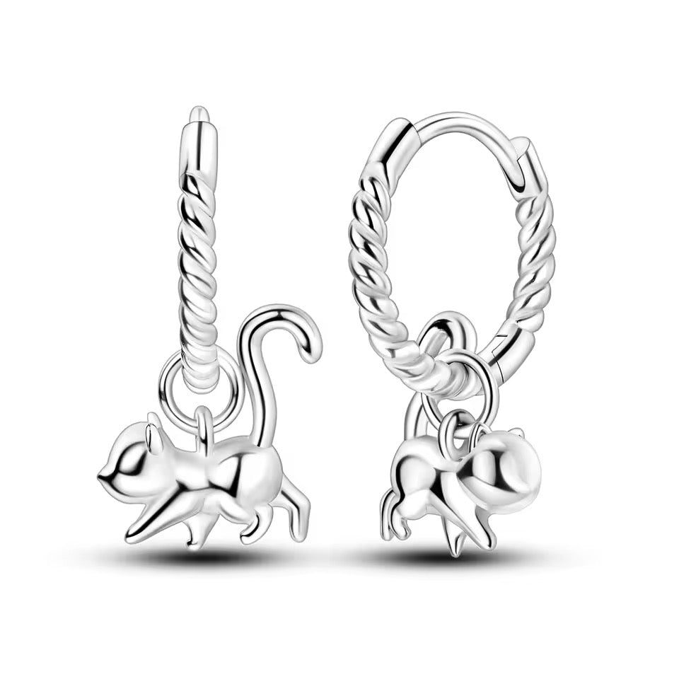 Silver hoop earrings with an acrobatic cat dangling from the hoop. 