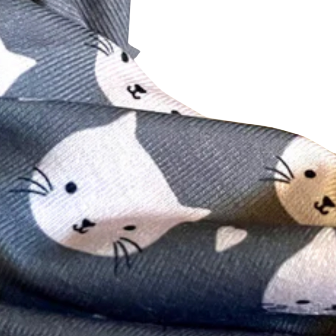 closeup of pink cat heads with whiskers on grey fabric buff beanie hat 