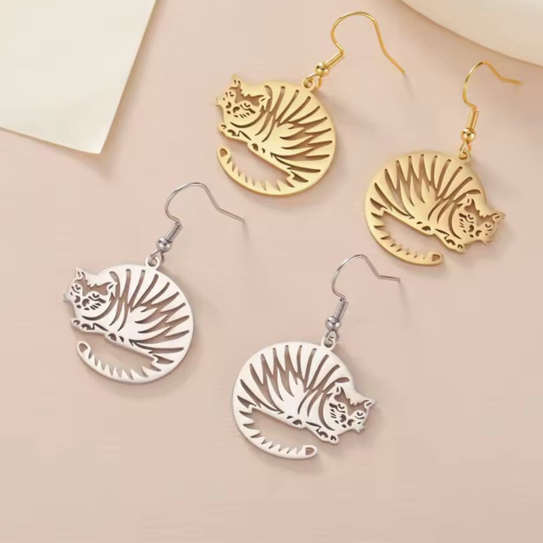 Gold and silver tiger-striped cat  earrings on a beige background
