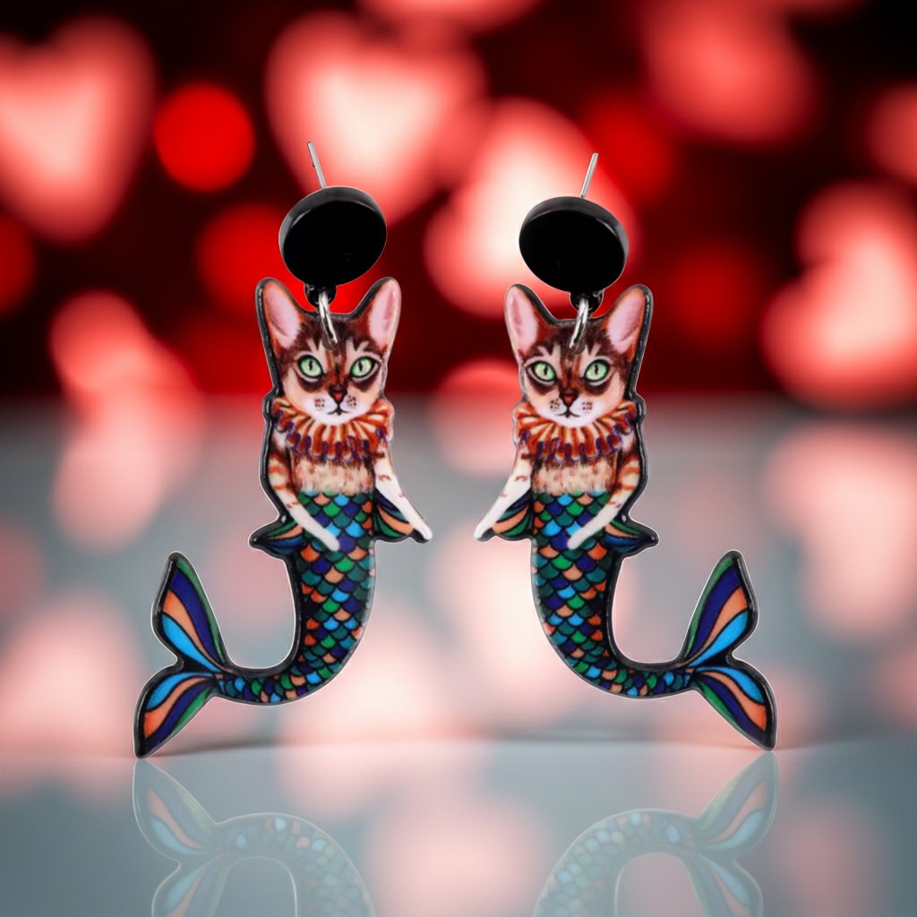 Cat mermaid tail earrings with a colorful Valentine design on a blurred background