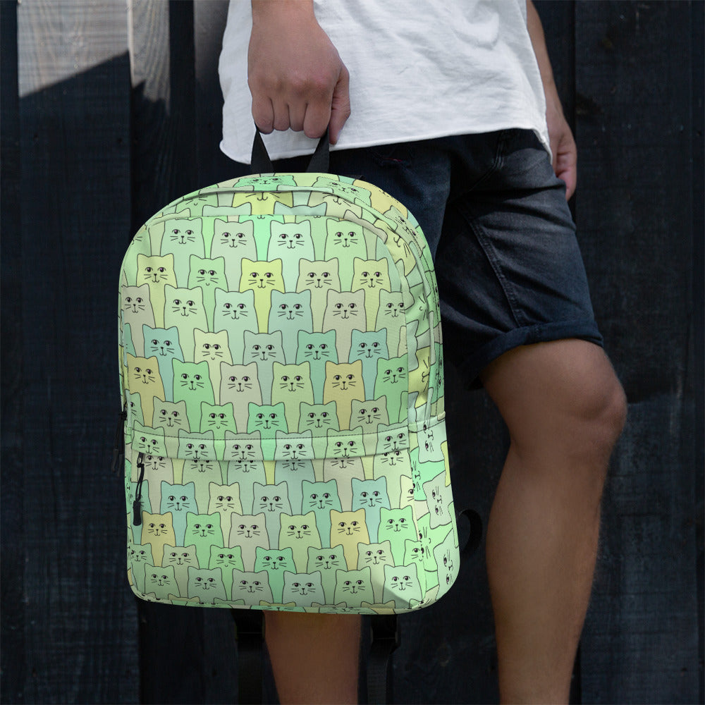 Man holding green cat patterned backpack