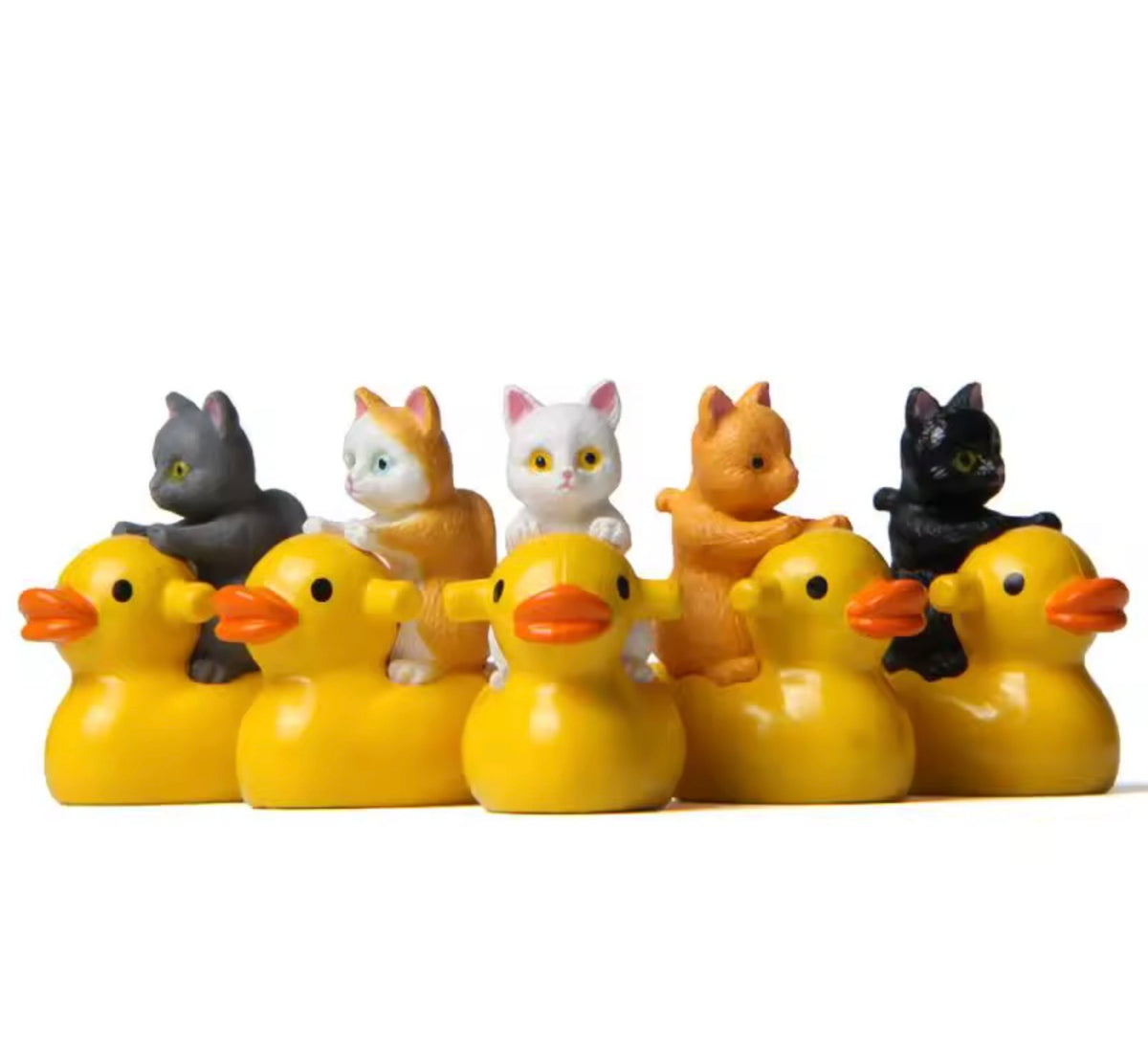 Set of rubber ducks with cat-shaped tops on a white background